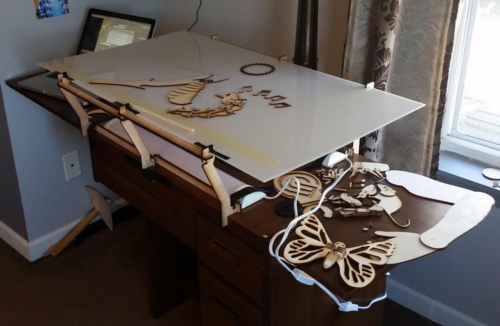 Owen used an old, heavy combination sewing machine/desk as the base for the light table. The supports for the translucent white acrylic were designed in Fusion360 and cut out using a Glowforge Pro.